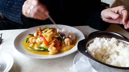 Frau isst Reis zu Garnelen Gemüse Curry in Vietnamesischen Restaurant