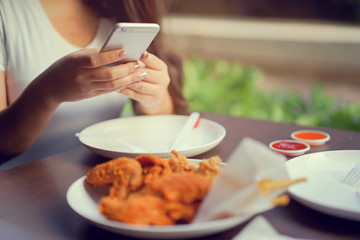 close up asian woman hand using smart phone for take a photo of lunch meal for upload on social media at outdoor restaurant with happy moment time , people lifestyle concept