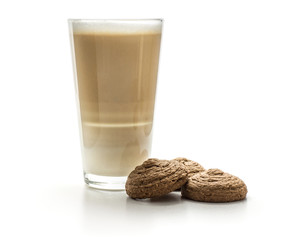 Three cocoa oat cookies with a glass of cappuccino isolated on white background drop shape brown crispy biscuits.