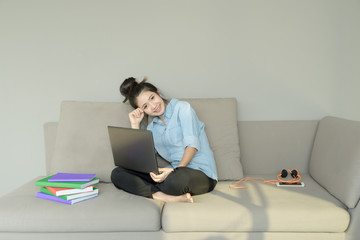 Business woman using laptop sitting on sofa. Young girl shopping online use notebook surfing internet. happy mood on cozy couch. Business and working concept.