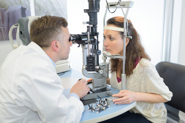 male optician giving female patient an eye test