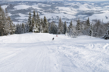 Fototapeta na wymiar Skiers on the ski slope in the snowy Carpathian mountains