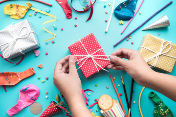 Obraz premium Celebration,party backgrounds concepts ideas with female hand decorating colorful gift box present with element confetti,balloon