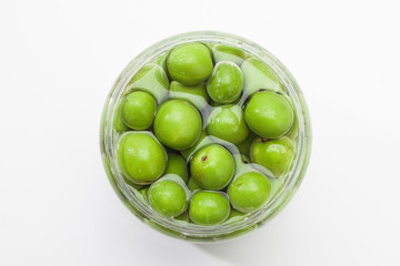 Canned Green plum in a glass jar 