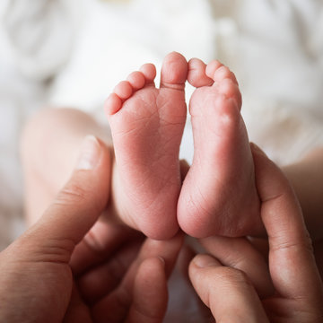 feet for newborns in mother's hands