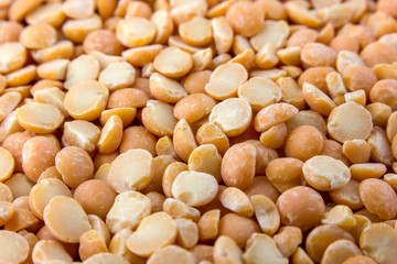 A pile of chopped peas scattered on the surface. Dry peas of yellow color close-up.
