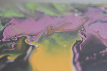Trendy colorful artistic abstract marble background with shallow depth of field. Pink, yellow, green, black. Matte filter. Pastel colour.