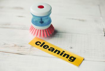 Cleaning house or office concept. Colorful cleaning brush and Cleaning inscription on a white...