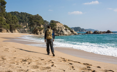 man walking among the rocks near a beach paradise