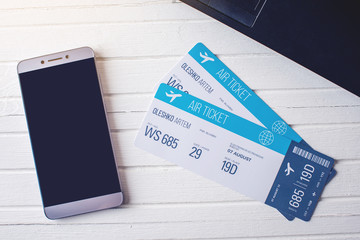 Two tickets are on the table with a phone. Concept of buying the online ticket booking for travel