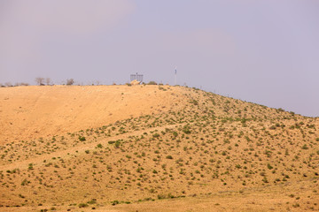 Fototapeta na wymiar Chanukiah on hill in desert under blue sky