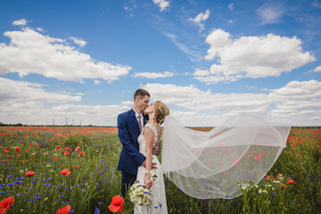 The first kiss of a newly formed wedding family. Beautiful bride and handsome man groom kissing in a forest
