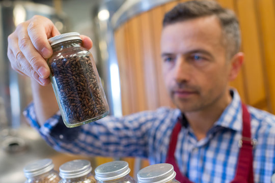 man holding pot of coffee beans