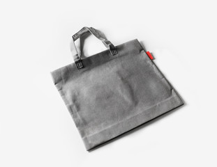 Naklejka premium Blank gray shopping canvas bag on white paper background.