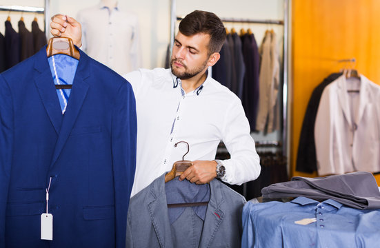 Young man customer choosing jacket