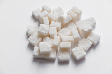 pressed sugar cubes sugar refined on a textured wooden surface and on a white background isolate