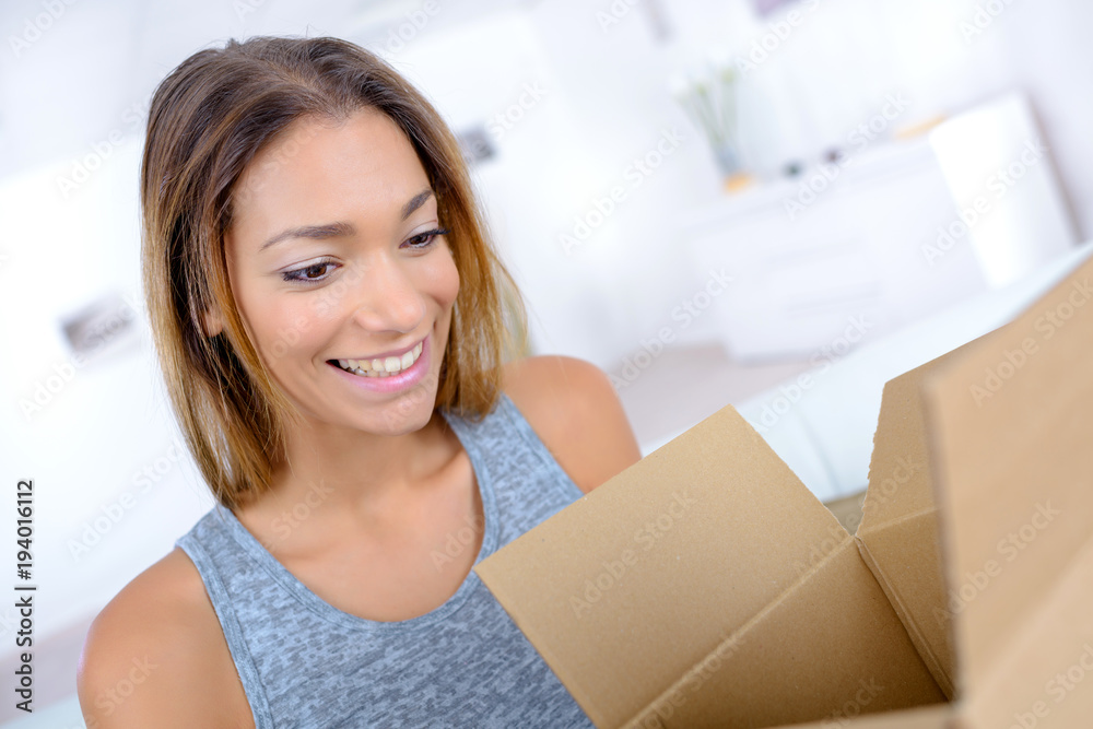 Wall mural attractive woman opening a cardboard box