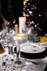Glass of gin tonic with lemon and cucumber on a table on new year's eve party