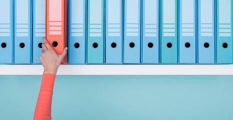 Office worker taking a folder in the archive