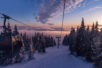 The cabin lift at Snezka. The cable car to Snezka hill. Winter landscape lit by the sunset in the beautiful colors of the winter. Sunset in the Giant Mountains.