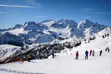 Fototapeta na wymiar Skiers in front of Marmolada and Gran Vernel group on Italian Dolomites. Italy.