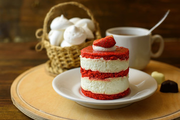 cake with strawberries, biscuits and a Cup of tea on a wooden table