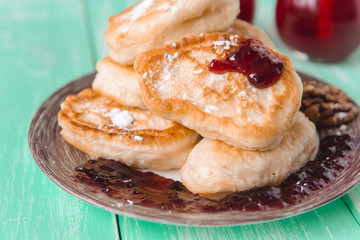 pancakes with jam and glasses of juice on a wooden table