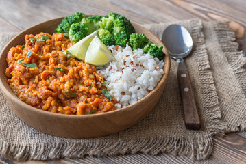 Bowl of red lentil curry with white rice and broccoli