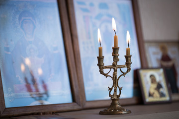 candle against the background of orthodox icons