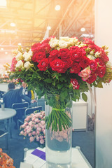 A group of businessmen is negotiating in the office for the sale of flowers on the background of a large bouquet of colorful roses. Conclusion of contracts.