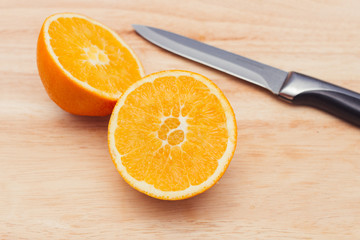 Orange aufgeschnitten auf Holz mit Messer