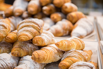 Tasty fresh croissants and rolls on a counter in shop
