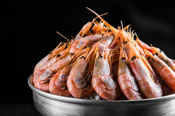 cooked Shrimps in a metal bucket on a dark background