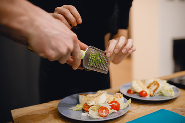 Preparation of fresh salad from cherry tomatoes, fried cheese, Peking cabbage, chilli and mango sauce