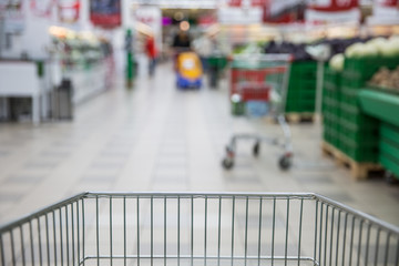 Trolley for products on supermarket background