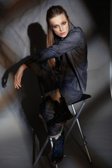 artistic portrait of a woman in a denim suit on a gray background