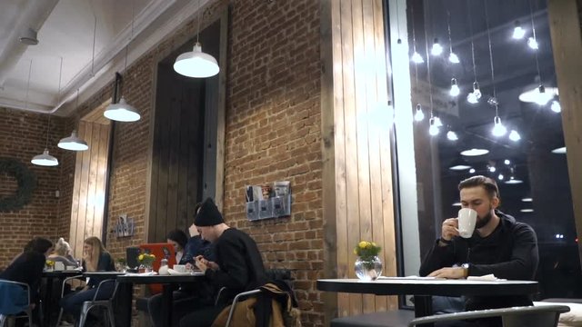 Guy is drinking coffee in cafe