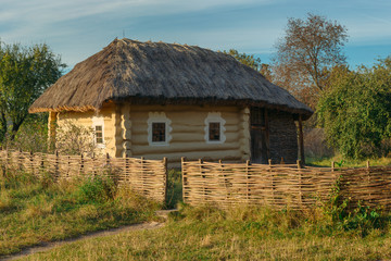 Fototapeta na wymiar Old rural house with wattle fence in village