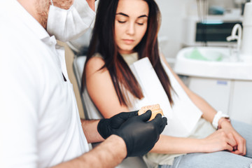 Fototapeta premium Dentist showing for the happy patient result of treatment