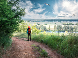 Tourist standing on the road atop hill under blue sky