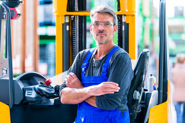 Baumarkt-Mitarbeiter im Lager für Heimwerkerbedarf mit Gabelstapler  © Kzenon