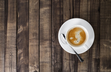 Coffee cup on wood table background. Top view with copyspace for your text.