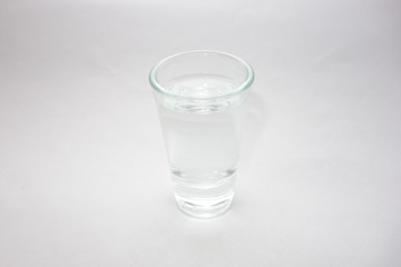 Single glass of strong alcohol on white background