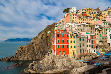 Fototapeta na wymiar Riomaggiore - first city of the Cique Terre sequence of five hill cities in Liguria, Italy. Great winter seascape of Mediterranean sea. Travel background.