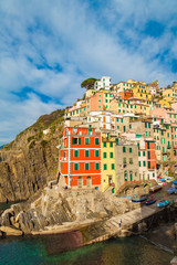 Fototapeta na wymiar Riomaggiore - first city of the Cique Terre sequence of five hill cities in Liguria, Italy. Great winter seascape of Mediterranean sea. Travel background.