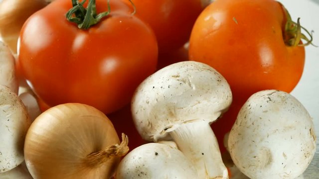 4K UHD footage of various vegetables slow rotating with tomato, mushrooms, onions, cucumbers and other