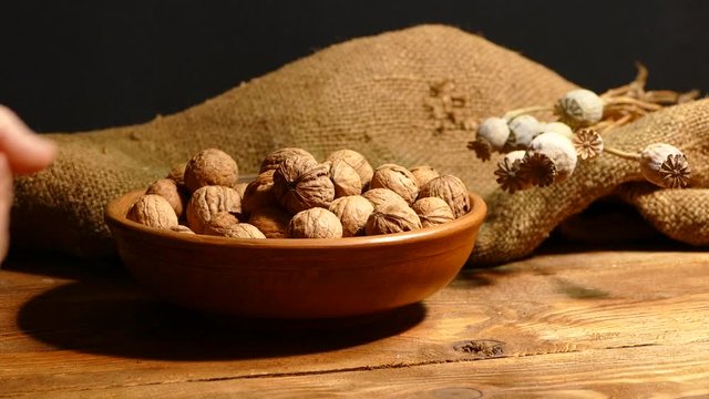 Walnut in the shell in a plate on the table. Strew the shell of nuts. Kernels of nuts.