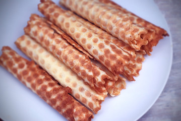 Waffle Tobes or Rolls. Homemade Dessert. White Plate. top view. Toned.