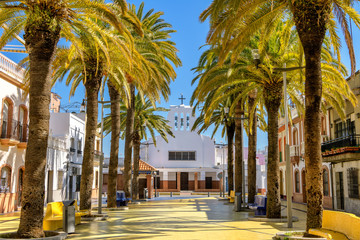 View of Jesus del Gran Poder church and picturesque Walk of Palms plaza in old town Isla Cristina, Huelva, Spain