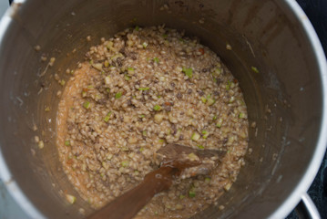 Pearl Porridge in a Saucepan, Close up, in Metallic Saucepan with wooden Spoon. Top view.